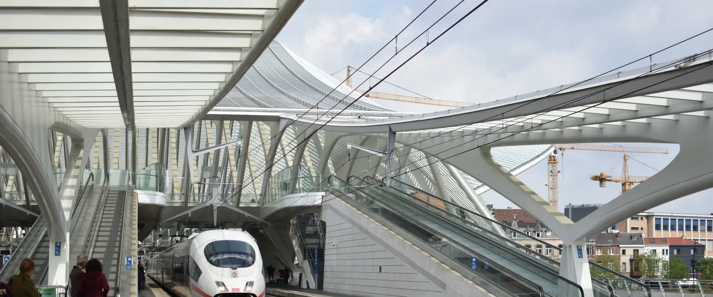 A Deutsche Bahn ICE high-speed train stopped at the platform beneath the sweeping Calatrava-designed canopy of Liège-Guillemins station in Belgium.
