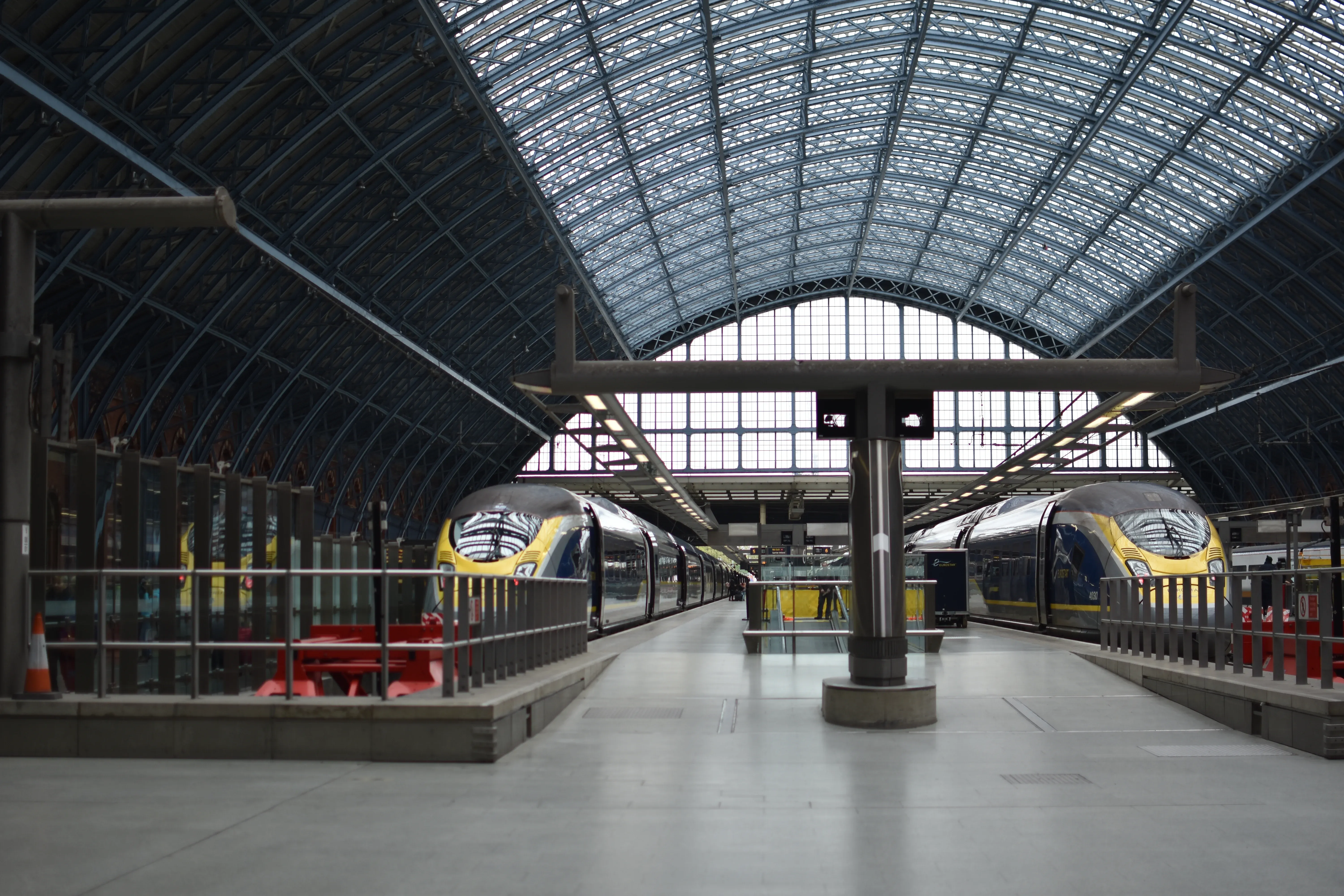 Interior of London St Pancras International station showing Eurostar e320 high-speed trains parked beneath the historic blue wrought-iron Barlow train shed.