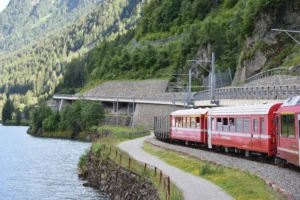 Scenic Bernina Pass train journey with breathtaking views of Lake Poschiavo and the Swiss Alps.